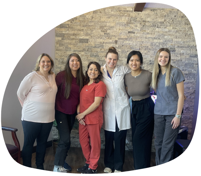 Flagstaff dentist and dental team gathered in front of wall