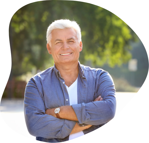 Older man smiling with his arms folded